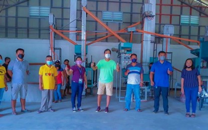 <p><strong>RICE PROCESSING CENTER</strong>. Kidapawan Mayor Joseph Evangelista (center in green shirt) gestures the thumbs-up sign together with village officials and representatives from the city agriculture office following the turnover of the PHP6-million rice processing center in Barangay San Isidro on Saturday (Sept. 4, 2021). The facility is expected to serve over 400 small-scale farmers in eight rice-producing villages of the city.<em> (Photo courtesy of Kidapawan CIO)</em></p>