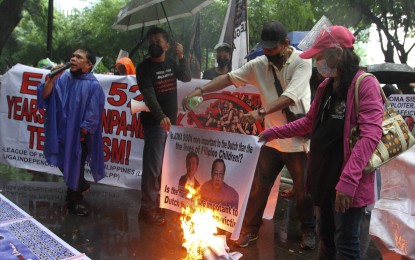 <p><strong>FILIPINO YOUTH MATTERS.</strong> Under pouring rain, members of Liga Independencia Pilipinas, League of Parents of the Philippines, and Yakap ng Magulang burn the images of Jose Maria Sison during a picket rally in front of the Embassy of the Kingdom of the Netherlands along Paseo de Roxas in Makati City on Wednesday (Sept. 8, 2021). The groups renewed their call for the European nation to stop coddling Sison, who is the Communist Party of the Philippines' founding chair.<em> (PNA photo by Avito C. Dalan)</em></p>