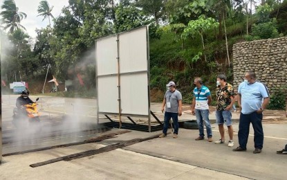 <p><strong>ANTI-ASF.</strong> Department of Agriculture (DA) 9 (Zamboanga Peninsula) officials observe how the wall-mounted disinfectant works, at the border of Zamboanga del Norte province in Rizal town on Friday (Sept. 10, 2021). The portable wash bays, one of two installed in the region, is part of measures to prevent the entry of African swine fever. <em>(Photo courtesy of DA-ZamPen)</em></p>