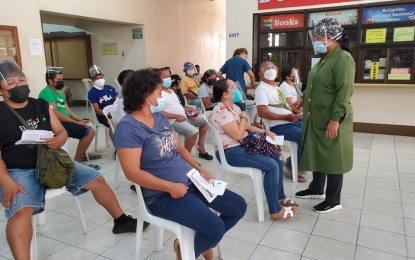 <p><strong>VACCINATION</strong>. Dr. Ma. Theresa Bad-ang (standing), president of the Philippine Society of Nephrology–Mindanao, talks with vaccinees who will get their second dose of the Covid-19 jab on Monday (Sept. 13, 2021) at Holy Cross of Davao College. The three-day rollout targets to vaccinate 1,200 dialysis patients, kidney transplant recipients, and their watchers in hospitals. <em>(PNA photo by Che Palicte)</em></p>