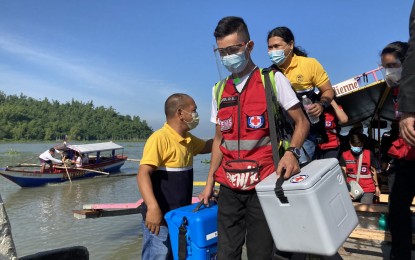 <p><strong>ALWAYS READY TO HELP</strong>. Philippine Red Cross volunteers get off a boat to visit villages in Talim Island in Rizal province to vaccinate the elderly and PWDs against the Covid-19.<em> (Photo courtesy of PRC)</em></p>