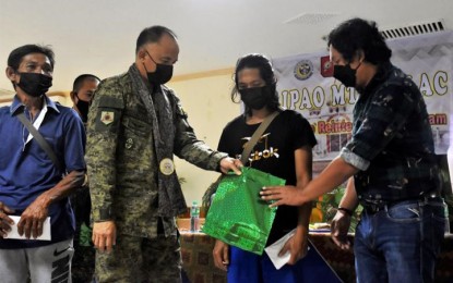 <p><strong>EX-BANDITS.</strong> A father and son, who are former members of the Abu Sayyaf Group, receive initial assistance from Maj. Gen. William Gonzales (2nd from left), commander of Joint Task Force-Sulu on Tuesday (Sept. 14, 2021). The two, who surrendered to the 2nd Special Forces Battalion in the province, will be enrolled in the ASG returnee reintegration program of the Municipal Task Force to End Local Armed Conflict. <em>(Photo courtesy of JTF-Sulu Public Affairs Office)</em></p>