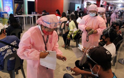 <p><strong>HEALTH CHECK.</strong> Medical workers assess the condition of vaccinees before administering the second dose of the Covid-19 jab at a mall in Dasmariñas City, Cavite on Friday (Sept. 17, 2021). At least 681 were inoculated with Sinovac. <em>(PNA photo by Gil Calinga)</em></p>