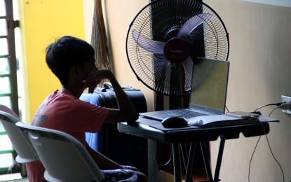 <p><strong>ONLINE CLASS.</strong> A Grade 6 student listens to his online class using a laptop inside their house in Imus, Cavite on Tuesday (Sept. 21, 2021). The Department of Social Welfare and Development will lead a webinar on Sept. 22 and 24 to promote safe use of the internet by children. <em>(PNA photo by Jess M. Escaros Jr.)</em></p>