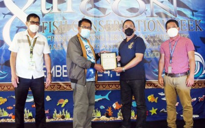 <p><strong>FISH CENTER RECIPIENT.</strong> Municipal Planning and Development Coordinator Nasirin Napii (3rd from left) of Ampatuan, Maguindanao receives the certificate for the PHP3-million community fish landing center from MAFAR-BARMM Minister Mohammad Yacob (2nd from left) on Tuesday (Sept. 21, 2021). The town is one of the local governments in Maguindanao situated along the vast Liguasan Marsh, home to rich natural resources like the freshwater tilapia fish, among others. <em>(Photo courtesy of Bangsamoro Information Office-BARMM)</em></p>