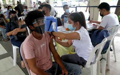 <p><strong>FULL JAB.</strong> A medical front-liner administers the second dose of the Covid-19 vaccine at the Quezon City Hall on Friday (Sept. 24, 2021). A total of 23,416,857 Filipinos have completed their full doses as of September 23. <em>(PNA photo by Rico H. Borja)</em></p>