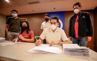 <p><strong>BUSINESS SUPPORT.</strong> Quezon City Mayor Joy Belmonte (seated, left) and Councilor Franz Pumaren, the council majority leader, sign a Memorandum of Agreement for a stimulus package for small and medium enterprises on Monday (Sept. 27, 2021). A total of 114 small businesses with 5,500 employees will benefit from the Kalingang QC sa Negosyo program. <em>(Photo courtesy of QC Government Facebook)</em></p>