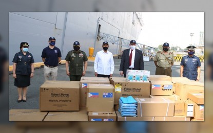 <p><strong>AUSSIE MEDICAL AID</strong>. Defense Secretary Delfin Lorenzana (in white barong), AFP Chief Lt. Gen. Jose Faustino Jr. (3rd from left), and Australian Ambassador to the Philippines Steven Robinson (3rd from right) pose with the PHP57 million worth of medical supplies donated by Australia in a simple ceremony at Pier 15, Manila South Harbor on Tuesday (Sept. 28, 2021). These supplies are the third tranche of donations under the Australia-Philippines Enhanced Defense Cooperation Program. <em>(Photo courtesy of the AFP)</em></p>