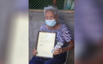 <p><strong>CENTENARIANS.</strong> Centenarian Dionela A. Gonzaga of Barangay San Pedro, San Jose de Buenavista proudly shows her felicitation letter and PHP100,000 cash incentive from government on Sept. 27, 2021. Anakalusugan party-list Rep. Michael Defensor on Sunday (Oct. 3) said a total of 7,322 centenarian Filipinos have already received their one-time PHP100,000 cash award since the passage of the Centenarians Law of 2016. <em>(Photo courtesy of San Jose de Buenavista LGU)</em></p>