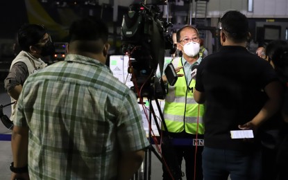 <p><strong>PRESS TIME.</strong> National Task Force Against Covid-19 Chief Implementer Secretary Carlito Galvez Jr. (wearing green reflectorized vest) replies to the questions from media personnel during the arrival of 391,950 doses of Pfizer vaccine at the NAIA Terminal 3, Pasay City on Wednesday (Sept 29, 2021). Department of Health Undersecretary of Health, Procurement and Supply Chain Management Team Usec. Ma. Carolina Vidal-Taiño and other government personnel also witnessed the arrival of the jabs. <em>(PNA photo by Robert Oswald P. Alfiler)</em></p>