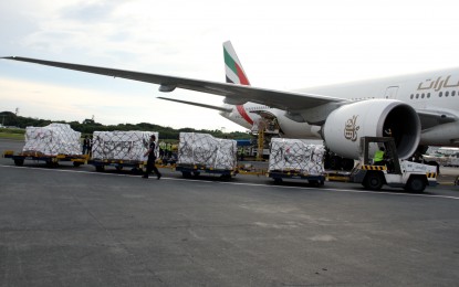 <p><strong>VAX SHIPMENT</strong>. An airport towing tractor pulls four baggage trailers loaded with boxes of the Pfizer Covid-19 vaccine at the Ninoy Aquino International Airport Terminal 3 on Friday (Oct. 1, 2021). The shipment of 883,350 doses will ramp up the country's inoculation drive. <em>(PNA photo by Jess M. Escaros Jr.)</em></p>