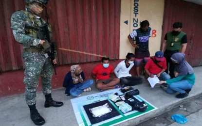 <p><strong>DRUG BUST.</strong> Joint Marines and Philippine Drug Enforcement Agency operatives arrest three alleged big-time drug pushers Saturday (Oct. 2, 2021) in Bongao, Tawi-Tawi. A Marine soldier (left) stands guard while PDEA agents conduct an inventory of the confiscated shabu and other pieces of evidence from the suspects. <em>(Photo courtesy of Marine Battalion Landing Team-12)</em></p>
