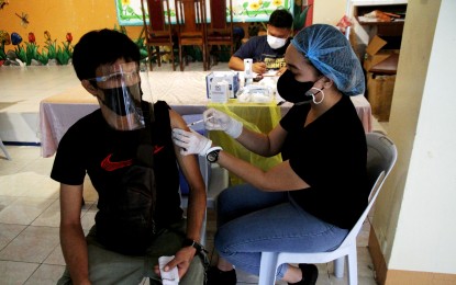 <p><strong>JAB.</strong> A medical front-liner administers the Covid-19 vaccine at the Sto. Cristo Elementary School, Quezon City on Aug. 12, 2021. As of Monday (Oct. 4, 2021), the city government has already deployed 3,247,750 doses.<em> (PNA photo by Rico H. Borja)</em></p>