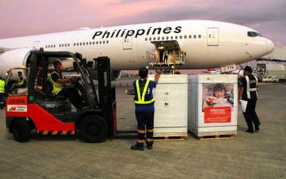 <p><strong>COVID-19 JABS.</strong> Crates containing boxes of government-procured Sinovac vaccines are unloaded at the Ninoy Aquino International Airport Terminal 2 on Friday (Oct. 1, 2021). At least 77.4 million of the life-saving jabs have been delivered to the Philippines as of Monday (October 4). <em>(PNA photo by Jess M. Escaros Jr.)</em></p>
