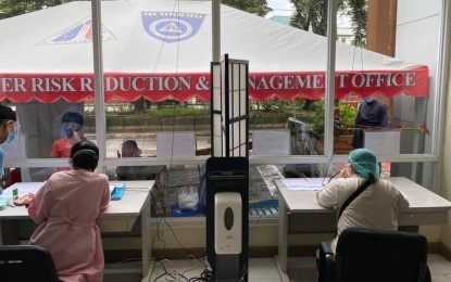 <p><strong>FUSION.</strong> Doctors at the Rosario Maclang General Hospital along Batasan Road, Quezon City attend to patients, separated by a glass partition, using an intercommunication device on Oct. 4, 2021. Patients availing of telemedicine will be scheduled for the physical consultation after evaluation.<em> (Photo courtesy of QC Government Facebook)</em></p>