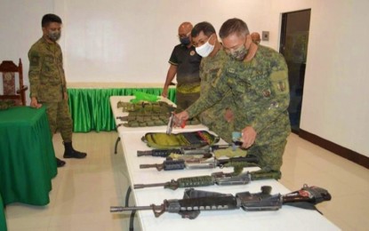 <p><strong>UNLICENSED GUNS</strong>. Soldiers inspect the guns found in the possession of a village official in Pikit, North Cotabato on Friday (Oct. 8, 2021). The guns were seized by government forces during the implementation of a gun ban near the Comelec office in the area. <em>(Photo courtesy of 6ID)</em></p>