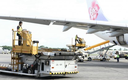 <p><strong>MORE MODERNA JABS.</strong> Two airport personnel prepare hydraulic scissor lifts to unload the additional delivery of 1,363,300 doses of Moderna Covid-19 vaccine at the NAIA Terminal 1 in Parañaque City on Saturday (Oct 9, 2021). Of the new shipment, 885,700 were procured by the government while 477,600 doses were bought by the private sector. <em>(PNA photo by Robert Oswald P. Alfiler)</em></p>