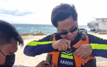 <p><strong>SUBMERGED ISLAND</strong>. Lapu-Lapu City Mayor Junard Chan puts on a life vest prior to boarding a pump boat to verify a report that the entire Caubian Island is submerged in seawater on Monday (Oct. 11, 2021). The mayor said it was the first time that Caubian, the smallest and farthest island barrio in Lapu-Lapu City, was flooded with seawater. <em>(Contributed photo)</em></p>