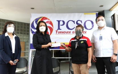 <p><strong>AID FUNDS.</strong> PCSO general manager Royina Garma (2nd from left) turns over the check worth PHP1 billion to Bureau of the Treasury (BTr) Collecting Officer Purita Belgica in a ceremony at the PCSO main office in Mandaluyong City on Monday (Oct. 11, 2021). In April, the Department of Finance requested additional dividends from PCSO's retained earnings from its charity fund for 2019. <em>(PNA photo by Joey Razon)</em></p>