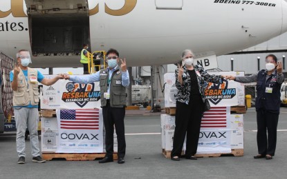 <p><strong>PFIZER DELIVERY.</strong> The latest shipment of Pfizer Covid-19 vaccines donated by the United States through the COVAX Facility arrives at the Ninoy Aquino International Airport Terminal 3 in Pasay City on Monday (Oct. 11, 2021). Unicef’s Bernardo Bersola, Assistant Secretary Wilben Mayor, US Embassy Cultural Affairs officer Nina Lewis, and Health Undersecretary Ma. Carolina Taiño pose with the boxes containing 924,300 doses of the US-made jabs.<em> (PNA photo by Avito C. Dalan)</em></p>