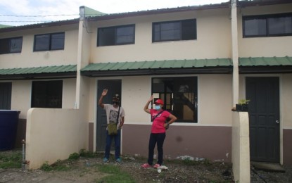 <p><strong>NEW HOUSES.</strong> Ka Kaloy (left), a former member of the communist New People's Army (NPA), and his wife pose for a photo in front of their house after the turnover ceremony on Tuesday (Oct. 12) at the Freedom Residences in Barangay Cuambugan, Tagum City in Davao del Norte. He is among the beneficiaries who received the housing units under the Enhanced Comprehensive Local Integration Program (ECLIP) of the government. <em>(Photo courtesy of 1001Bde)</em></p>