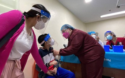 <p><strong>VACCINATION FOR KIDS.</strong> A boy receives his first dose of the coronavirus vaccine at the Pasig City Children's Hospital on Friday (Oct. 15, 2021). Some 89 children with comorbidities included in the hospital's master list pulled up their sleeves to get the life-saving shot. <em>(Photo courtesy of Pasig City PIO)</em></p>