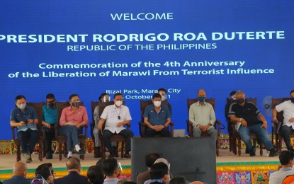 <p><strong>SPECIAL GUEST.</strong> President Rodrigo Duterte (4th from left) attends the commemoration activity of the fourth anniversary of the Marawi siege in Lanao del Sur on Saturday (Oct. 16, 2021). In his speech, he vowed the government will work double-time to complete all rehabilitation and infrastructure projects within his term. <em>(Photo courtesy of TFBM)</em></p>