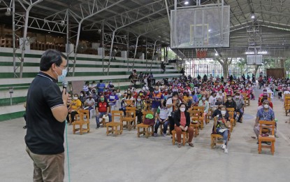 <p><strong>HOUSES FOR IPs</strong>. Tagum City Mayor Allan L. Rellon leads the distribution of the notices of award to the indigenous peoples who are beneficiaries of houses and lots at the Masandag Tribal Village in Barangay Canocotan on Oct. 14. The project is part of the resettlement program of the city government in partnership with the National Housing Authority. (<em>Tagum CIO photo by Vinz Davo</em>)</p>