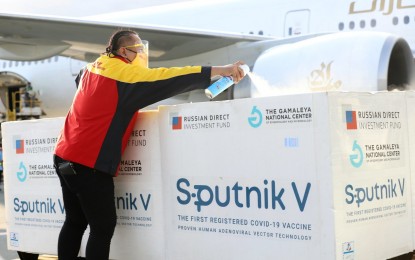 <p><strong>SANITATION.</strong> An airport worker disinfects the boxes containing 720,000 doses of the Sputnik V Covid-19 vaccine at the Ninoy Aquino International Airport Terminal 3 in Pasay City on Saturday (Oct. 16, 2021). The Philippines has so far administered 52,157,598 first and second doses. <em>(PNA photo by Robert Oswald P. Alfiler)</em></p>