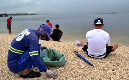 <p><strong>DOLOMITE BEACH.</strong> A worker from the Manila Department of Public Services picks pieces of trash at the Manila Bay dolomite beach along Roxas Boulevard, Manila on Monday (Oct. 18, 2021). The beach saw an influx of visitors over the weekend after Metro Manila was placed under Alert Level 3. <em>(PNA photo by Avito C. Dalan)</em></p>