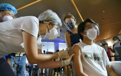 <p><strong>DOUBLE DUTY.</strong> Manila Vice Mayor Honey Lacuna, also a medical doctor, administers a Covid-19 vaccine shot during the inoculation of minors aged 12 years to 17 years at the Ospital ng Maynila on Friday (Oct. 22, 2021). Lacuna said the rollout would help pave the way for a safe return to physical classes. <em>(Photo courtesy of Manila PIO)</em></p>