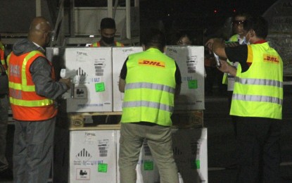 <p><strong>NEARING 100M</strong>. Bureau of Customs personnel inspect the cargo containing Pfizer vaccines that arrived at the Ninoy Aquino International Airport (NAIA) Terminal 3 on Friday night (Oct. 22, 2021). National Task Force Against Covid-19 chief implementer, Secretary Carlito Galvez Jr., said the number of doses of Covid-19 vaccines either procured by the government or donated is nearing the 100-million mark. <em>(PNA photo by Rico H. Borja)</em></p>