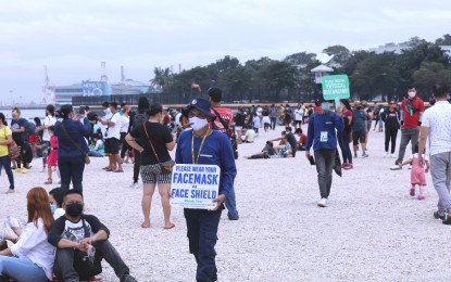 <p><strong>GENTLE REMINDER.</strong> Two marshals hold signage reminding visitors at the Manila Baywalk Dolomite Beach to observe minimum health protocols in this photo taken on Oct. 25, 2021. The Department of Environment and Natural Resources leads the Manila Bay rehabilitation which includes the creation of the Dolomite Beach. <em>(File photo) </em></p>