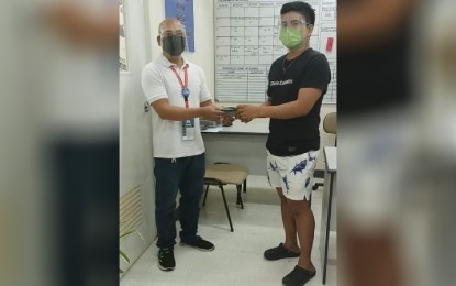 <p><strong>GOOD EXAMPLE.</strong> Mall maintenance worker Alexander Foronda (left) returns a wallet with P24,000 cash to the owner, Bonifacio Jose Jr., on Tuesday (Oct. 26, 2021). Foronda was cleaning an area of the mall when he saw the wallet. <em>(Photo courtesy of Krystal Gayle Agbulig)</em></p>