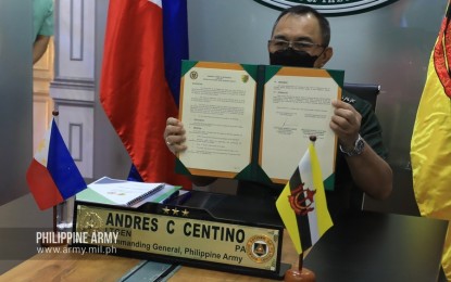 <p><strong>BOOSTING DEFENSE TIES.</strong> Army chief Lt. Gen. Andres Centino shows a copy of the amended terms of reference (TOR) on the memorandum of understanding (MOU) on defense cooperation with Brunei in a virtual ceremony on Monday (Oct. 25, 2021). Royal Brunei Land Forces commander Brig. Gen. Haji Muhammad Haszaimi bin Bol Hassan also signed the document during the ceremony. <em>(Photo courtesy of AFP)</em></p>