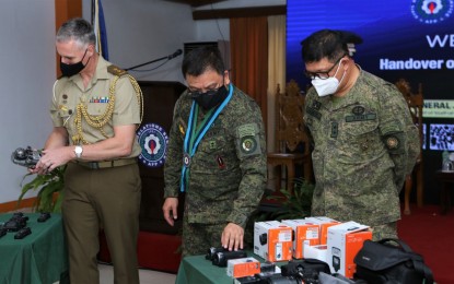 <p><strong>ANTI-EXTREMISM EQUIPMENT.</strong> AFP chief, Gen. Jose Faustino Jr. (center); CRSAFP commander, Maj. Gen. Manuel Sequitin (right), and Australian Assistant Defense Attache, Lt. Col. Timothy John Lopsik check out the equipment donated by the Australian government, in Camp Aguinaldo, Quezon City on Tuesday (Oct. 26, 2021). The equipment, which was turned over to the Civil Relations Service AFP, include high-tech computers, tablets, storage devices, smart TVs, cameras, and audio recording components which will be used in the AFP's anti-violent extremism campaign.<em> (Photo courtesy of AFP)</em></p>