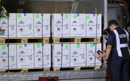 <p><strong>PFIZER SHOTS</strong>. Upon arrival at the NAIA Terminal 3 on Friday night (Oct. 29, 2021), Bureau of Customs officials inspect the latest shipment of the Pfizer vaccine. A total of 973,440 doses of Pfizer was the latest delivery made to the country. <em>(PNA photo by Joseph Razon)</em></p>