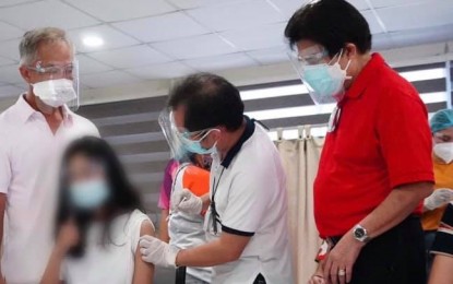 <p><strong>COVID-19 JAB FOR KIDS</strong>. Dr. Edwin Miraflor, officer-in-charge of Bacolod City Health Office, administers the Pfizer jab on a minor, in the presence of her parent and Mayor Evelio Leonardia during the launch of the A3 pediatric vaccination against Covid-19 at the Riverside College annex building last Friday (Oct. 29, 2021). Bacolod recorded the most number of teen vaccine recipients in a single venue on that day, nationwide data of the Department of Health showed. <em>(Photo courtesy of Bacolod City PIO)</em></p>