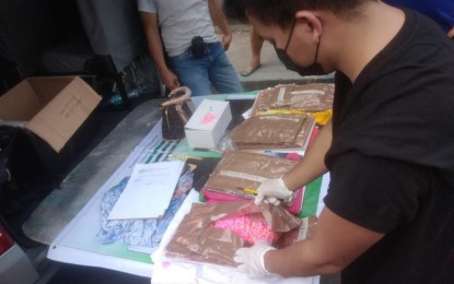 <p><strong>ECSTASY TABLETS.</strong> An anti-illegal drug operative inspects the PHP16.9 million worth of illegal drugs ecstasy seized from Elisha Mae Llas following a controlled delivery operation in Quezon City on Nov. 5, 2021. Philippine National Police (PNP) chief Gen. Guillermo Eleazar on Sunday (Nov. 7) said Llas could be part of a huge drug syndicate operating in Metro Manila. <em>(Photo courtesy of PNP)</em></p>