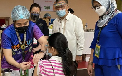 <p><strong>PEDIATRIC VACCINATION.</strong> Dr. Joshua Brillantes, Department of Health (DOH) Region 9 (Zamboanga Sibugay) director (in polo barong), and Dr. Dulce Amor Miravite (right partly hidden) observe the vaccination of children aged 12 to 17 as the inoculation of pediatric A3 (with comorbidity) and the rest of the pediatric population officially started on Monday (Nov. 8, 2021) in Zamboanga City. The city government activated five vaccination sites for this purpose. <em>(Photo courtesy of DOH-9)</em></p>