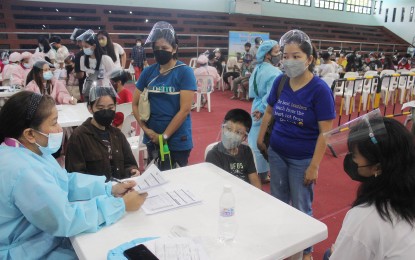 <p><strong>JABS FOR MINORS.</strong> Parents accompany their children for vaccination with the first dose of the Pfizer Covid-19 vaccine at La Salle Dasmariñas in Cavite on Tuesday (Nov. 9, 2021). The government has included the 12-17 age group in the vaccination rollout. <em>(PNA photo by Gil Calinga)</em></p>