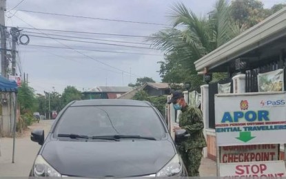 <p><strong>CHECKPOINT.</strong> A police officer checks on the requirements of a traveler before allowing entry to Pangasinan at a border checkpoint in Rosales town in Pangasinan on Nov. 9, 2021. The province has eased its requirements for fully vaccinated travelers.<em> (Photo courtesy of Rosales Police)</em></p>