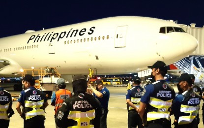 <p><strong>CARGO SECURITY. </strong>Airport cops stand guard as the latest shipment of the Sinovac Covid-19 vaccine arrives via Philippine Airlines at Ninoy Aquino Terminal 2 on Thursday night (Nov. 11, 2021). The shipment consisted of three million doses of government-procured jabs. <em>(PNA photo by Jess M. Escaros Jr.)</em></p>