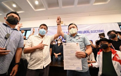 <p><strong>TOP ENDORSER.</strong> President Rodrigo Duterte (center) raises the arm of Senator Christopher “Bong” Go who filed his candidacy for president at the Commission on Elections office in Intramuros, Manila on Nov. 13, 2021. Go later withdrew and the President has not announced his support for his successor since then. <em>(Photo courtesy of SBG)</em></p>