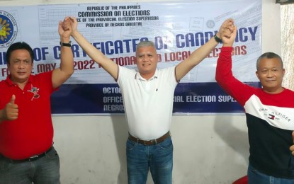 <p><strong>SUBSTITUTION</strong>. Negros Oriental Gov. Roel Degamo (left) raises the hand of Philippine Navy Col. Reynaldo Lopez, with Dauin Mayor Galicano Truita also joining them during the substitution filing of candidacy on Monday, Nov. 15, 2021. Lopez replaced Glib Estrella for the 3rd district congressional race in the May 9, 2022 polls. <em>(Photo courtesy of Bhoy Pilonggo)</em></p>