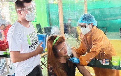 <p><strong>VAX ROLLOUT.</strong> Pandi, Bulacan Mayor Enrico Roque (left) supervises the conduct of the vaccination rollout in this March 2021 photo. He said the town is now nearing the desired population protection against Covid-19, having the highest percentage of inoculated residents among the local government units in the province. <em>(File photo by Manny Balbin)</em></p>