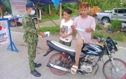 <p><strong>STRICT MEASURES.</strong> A police officer reminds motorists at a border checkpoint in Shariff Aguak, Maguindanao to wear their face masks properly as part of the implementation of quarantine protocols in the province. Starting Tuesday (Nov. 16, 2021), the police will also implement the “No Vaccination Card, No Entry” policy of the provincial government. <em>(Photo courtesy of Maguindanao PPO)</em></p>