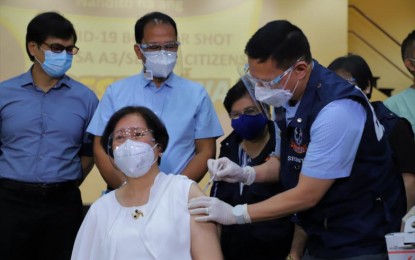 <p><strong>ADDED PROTECTION.</strong> Health Secretary Francisco Duque III administers a booster dose to vaccine expert panel chair Dr. Nina Gloriani during the ceremonial vaccination at the East Avenue Medical Center in Quezon City on Monday (Nov. 22, 2021). The government is now rolling out additional Covid-19 shots to the elderly and immunocompromised adults. <em>(Photo courtesy of NTF Against Covid-19)</em></p>