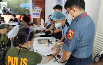 <p><strong>BOOSTER JABS.</strong> A police medical front-liner undergoes medical examination before getting a Covid-19 booster shot in Camp Crame, Quezon City on Monday (Nov. 22, 2021). A total of 591 medical front-liners assigned at the PNP headquarters in Camp Crame received booster shots during its rollout. <em>(Photo courtesy of the Office of the PNP Deputy Chief for Administration)</em></p>