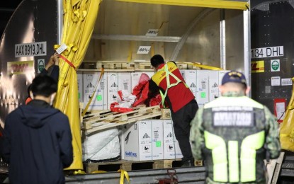 <p><strong>TRIPLE DELIVERY.</strong> A logistics worker takes charge of boxes containing 609,570 doses of the Pfizer Covid-19 jab at the Ninoy Aquino International Airport on Nov. 19, 2021. On the same day, 1,306,000 doses of Moderna and 2,810,000 of Sputnik V and Light were also delivered. <em>(PNA photo by Joey Razon)</em></p>